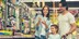 Mother checking list while father hugs daughter in an aisle filled with school supplies